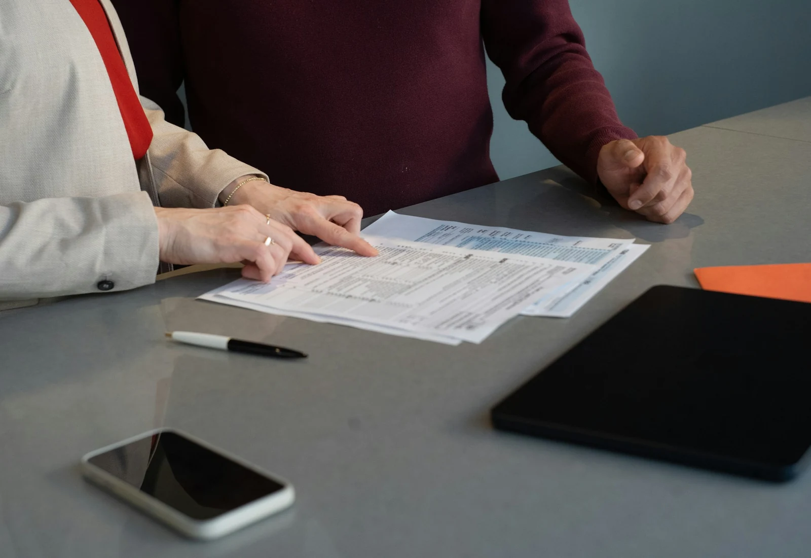 Two people reviewing paperwork together at a table